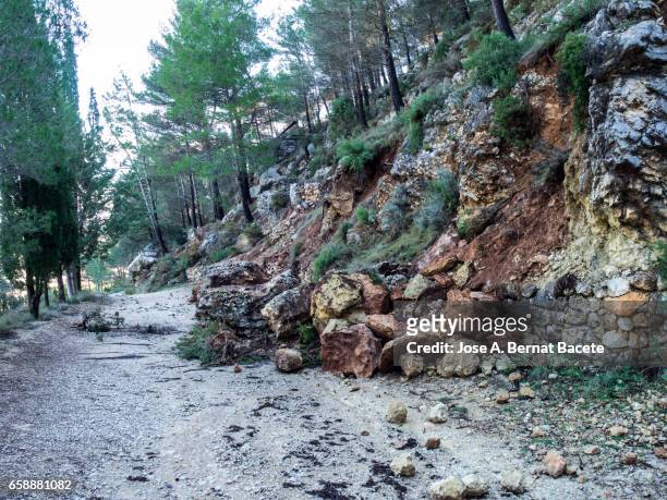 road of mountain cut by a landslide of rocks and mud for the strong rains - geología stock-fotos und bilder