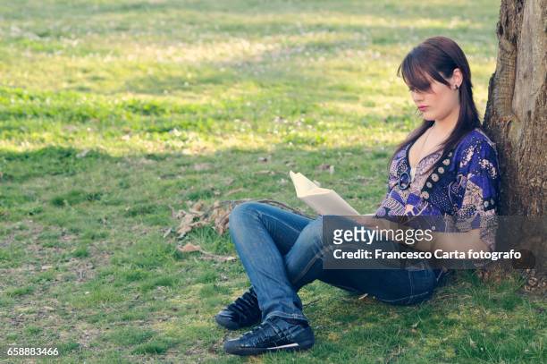 reading outdoors - leggere stock-fotos und bilder