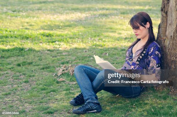 reading outdoors - gente comune ストックフォトと画像