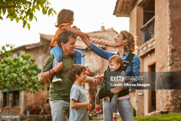 feliz madre y padre con niños en la yarda - family with three children fotografías e imágenes de stock