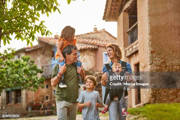 happy parents carrying children in back yard - cinco pessoas imagens e fotografias de stock