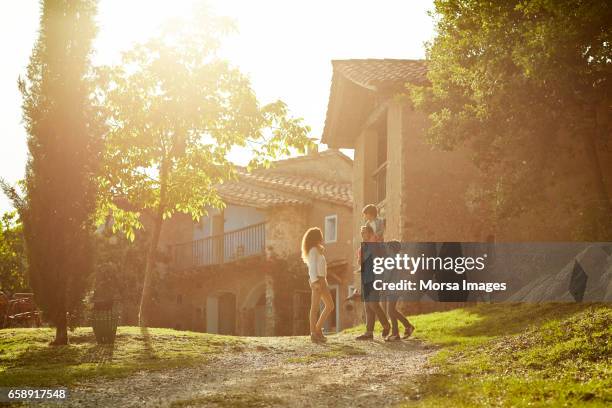 voller länge familie sich gegen häuser - mittlere entfernung stock-fotos und bilder