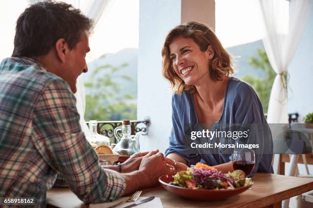 sonriente pareja hablando en el restaurante - citas románticas fotografías e imágenes de stock