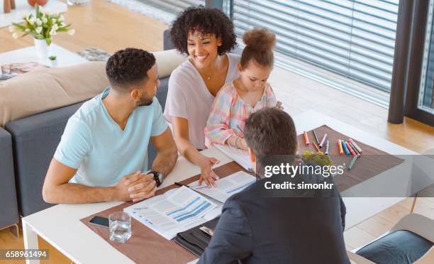 banker consulting married couple in their home - financial advisor with family stock pictures, royalty-free photos & images