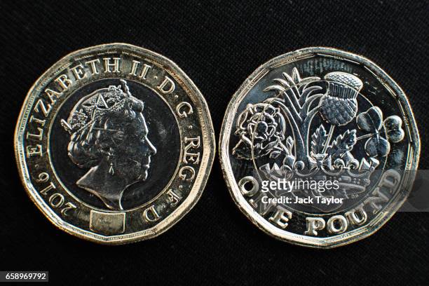 In this photo Illustration, the front and back of the newly issued £1 coin is arranged on display on March 28, 2017 in London, England. The new £1...