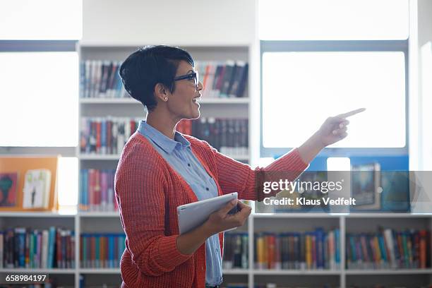 teacher talking to students, in the library - teacher pointing finger stock pictures, royalty-free photos & images