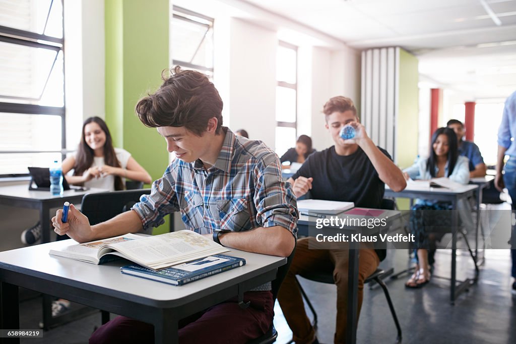 Student looking in book in classroom
