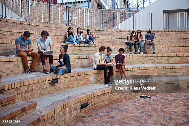 students studying in groups outside - university campus foto e immagini stock
