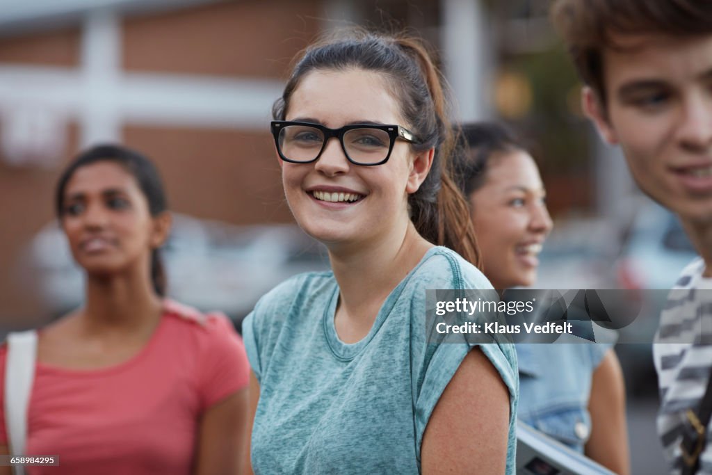 Portrait of cute smiling young woman among friends