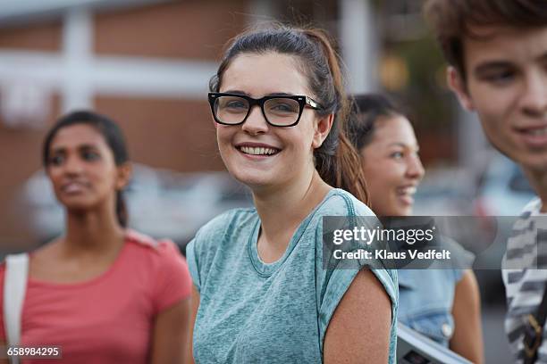 portrait of cute smiling young woman among friends - youth culture portrait stock pictures, royalty-free photos & images