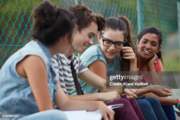 friends looking at watch together at school - 19 to 22 years and friends and talking stock pictures, royalty-free photos & images