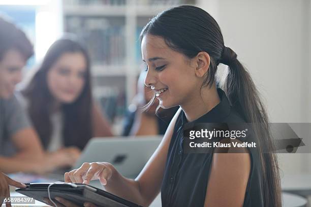 female student scrolling on tablet - 14 year old brunette girl stock pictures, royalty-free photos & images