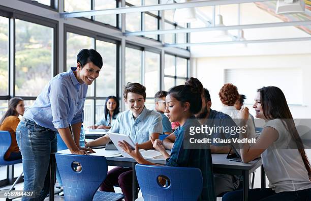 teacher assisting group of students in classroom - education building stock pictures, royalty-free photos & images