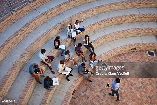 students having class in outside auditorium - campus photos et images de collection