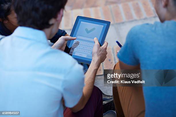 close- up of students using digital tablet - 3 teenagers mobile outdoors stock-fotos und bilder