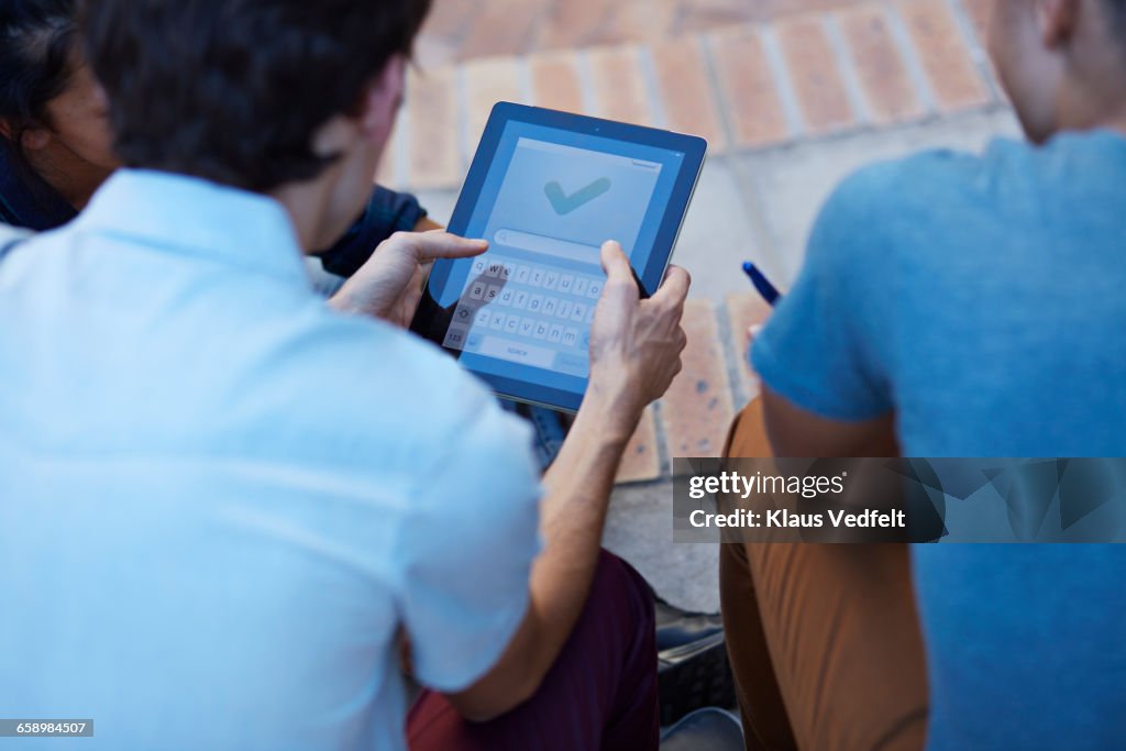 Close- up of students using digital tablet