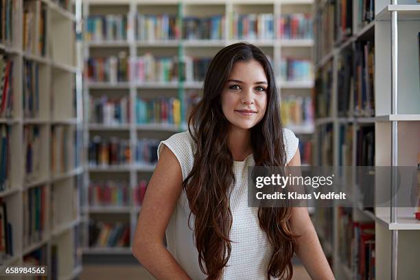 portrait of female student in library - attractive girl stockfoto's en -beelden