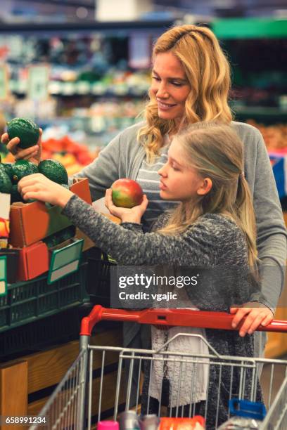 mother and daughter in a supermarket - girls shopping stock pictures, royalty-free photos & images