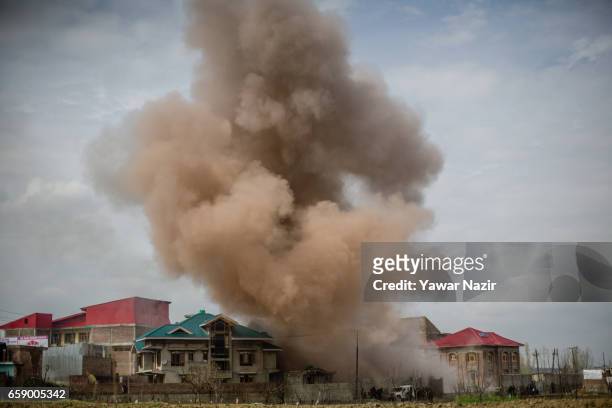 Smoke billows from a building during a heavy exchange of fire between militants and Indian government forces during a gun battle between militants...