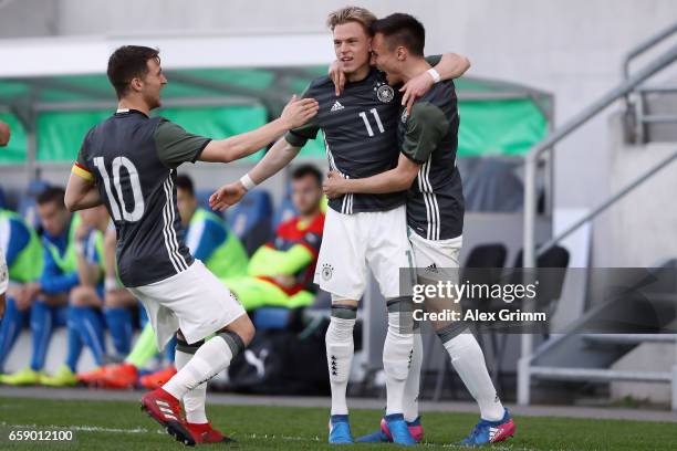 Robin Hack celebrates his team's first goal with team mate Dominik Franke and Salih Oezcan during the UEFA Elite Round match between Germany U19 and...