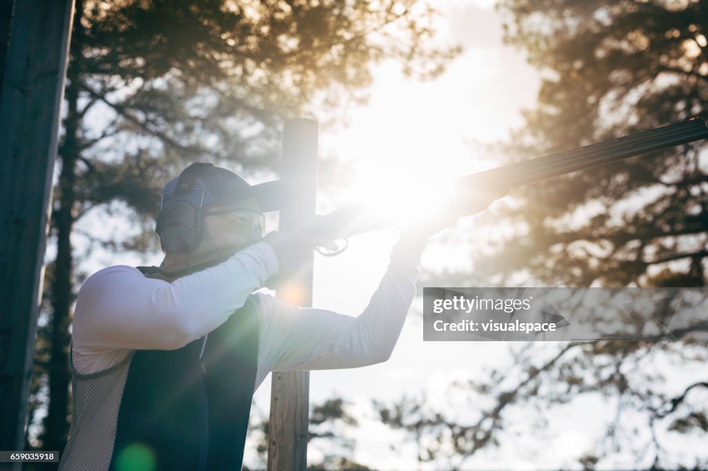 Clay target shooter in sunset