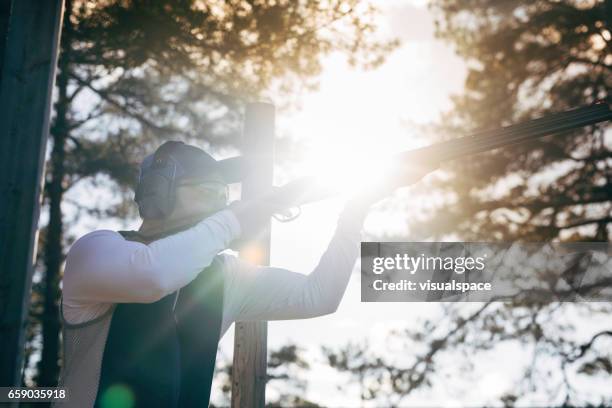 atirador de destino clay no pôr do sol - clay pigeon shooting - fotografias e filmes do acervo