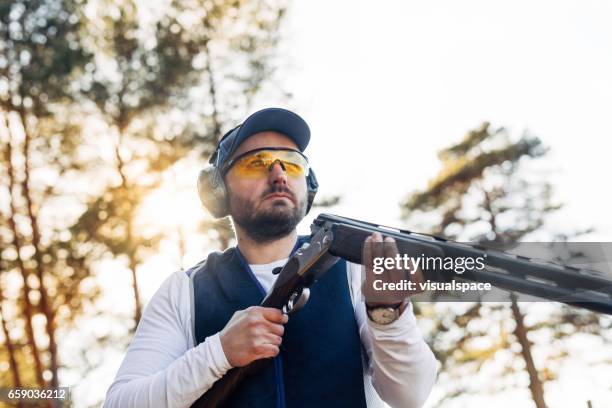 clay target shooter in sunset - target shooting stock pictures, royalty-free photos & images