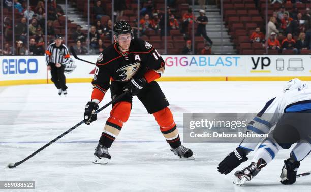 Corey Perry of the Anaheim Ducks skates with the puck against Mark Stuart of the Winnipeg Jets during the game on March 24, 2017 at Honda Center in...