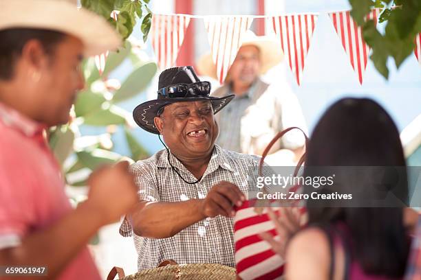 market trader selling tote bag to tourist - straatverkoper stockfoto's en -beelden