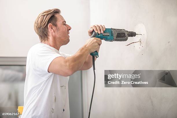 builder drilling into wall - drill stock pictures, royalty-free photos & images