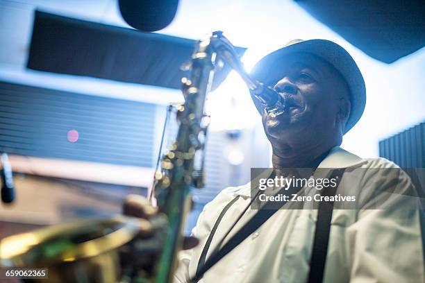 male musician in recording studio, playing saxophone - saxophonist stock pictures, royalty-free photos & images