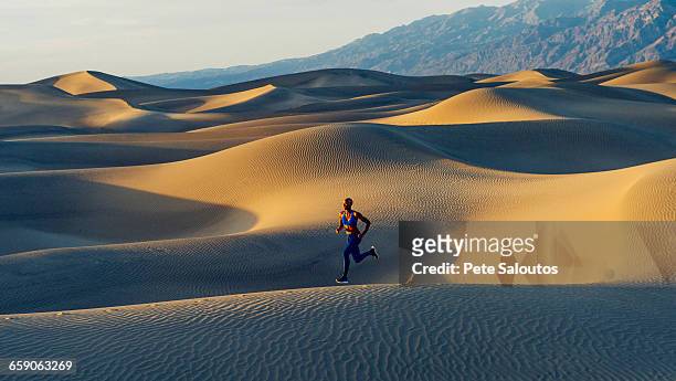runner sprinting in desert, death valley, california, usa - sable ondulé photos et images de collection