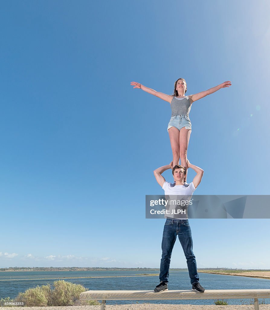 Couple Practising Partner Yoga On Beach Bench High-Res Stock Photo ...