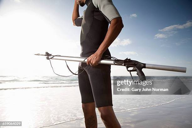 diver with speargun on beach - harpoon stock pictures, royalty-free photos & images