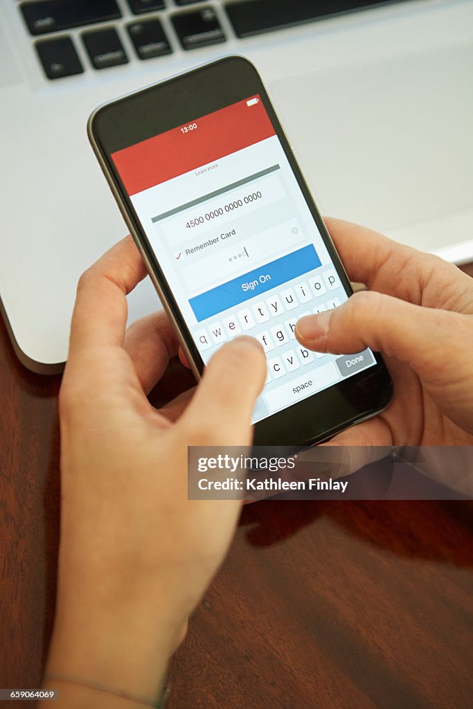 Womans hands holding smartphone signing on to internet banking