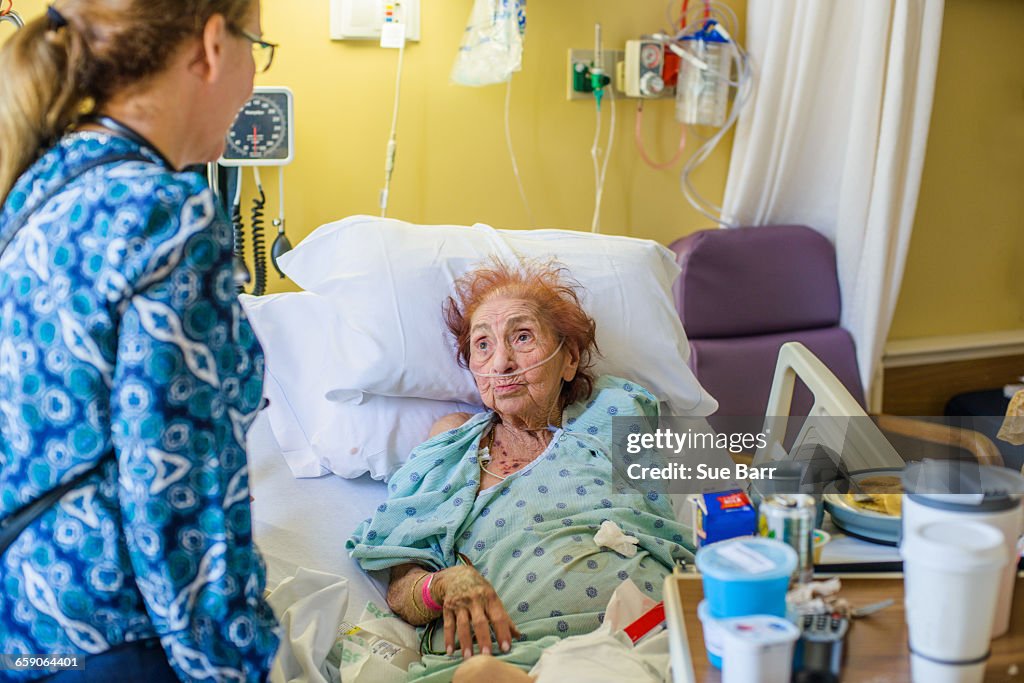 Patient on hospital bed talking to visitor