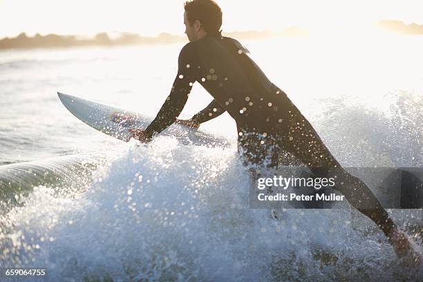 male surfer surfing into ocean wave on venice beach, california, usa - venice beach stock pictures, royalty-free photos & images