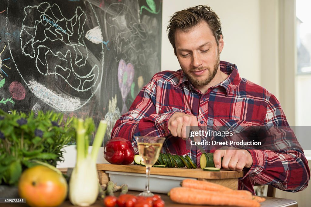 Man slicing vegetables on chopping board, Munich, Bavaria, Germany