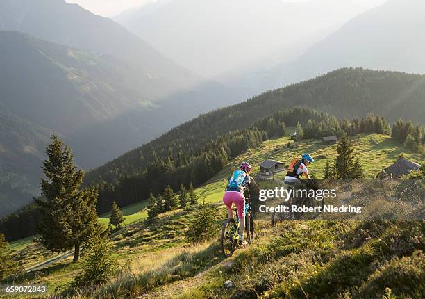 mountain bikers riding on uphill in alpine landscape, zillertal, tyrol, austria - zillertal stock pictures, royalty-free photos & images