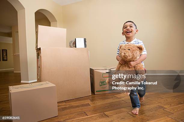 boy with teddy bear and moving boxes - child teddy bear stock-fotos und bilder