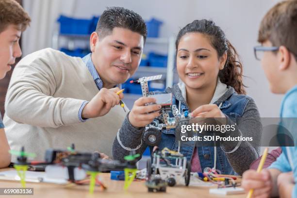 helpful teacher works with students in technology class - stem education stock pictures, royalty-free photos & images