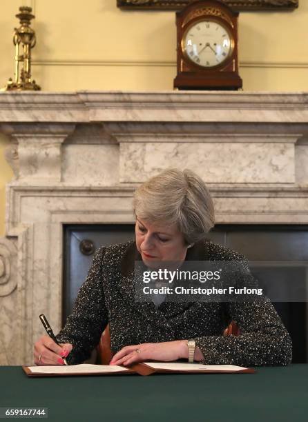 British Prime Minister Theresa May in the cabinet office signs the official letter to European Council President Donald Tusk invoking Article 50 and...