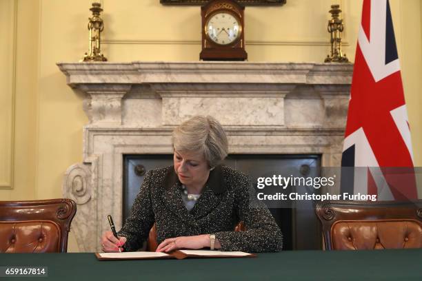 British Prime Minister Theresa May in the cabinet office signs the official letter to European Council President Donald Tusk invoking Article 50 and...