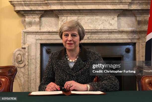 British Prime Minister Theresa May in the cabinet office signs the official letter to European Council President Donald Tusk invoking Article 50 and...