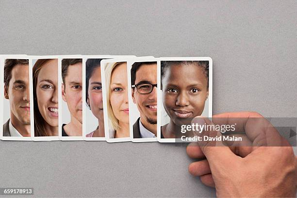 hand placing a card with a portrait in a row. - hand of cards stock-fotos und bilder