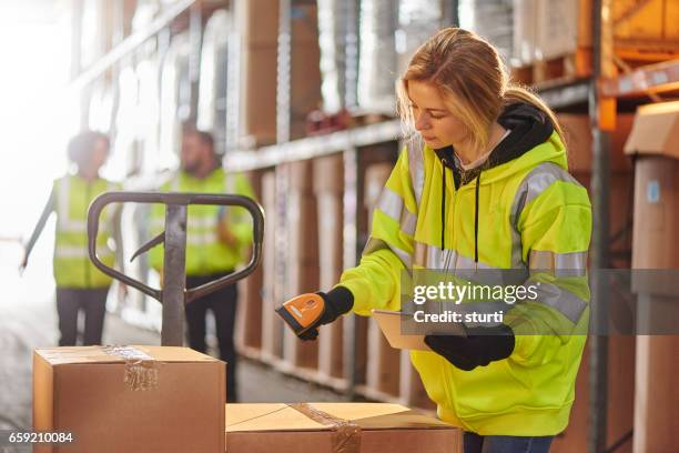 female warehouse operative - yellow glove stock pictures, royalty-free photos & images