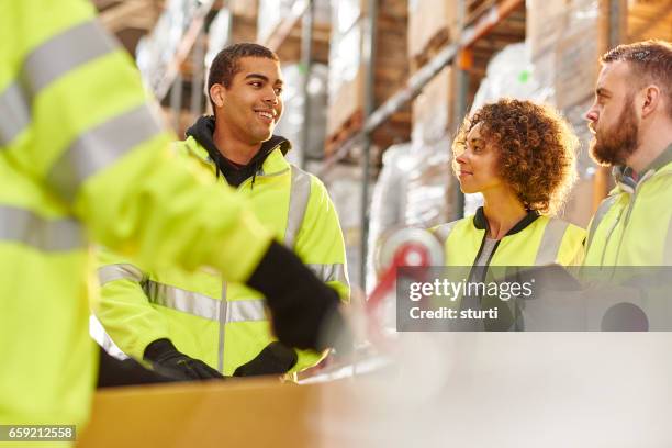 supervisor chatting to warehouse worker - warehouse worker stock pictures, royalty-free photos & images