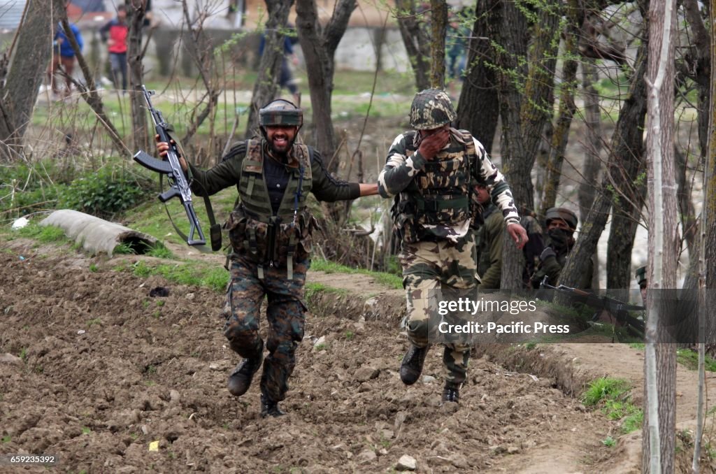 Indian army soldier helping a wounded colleague near the gun...