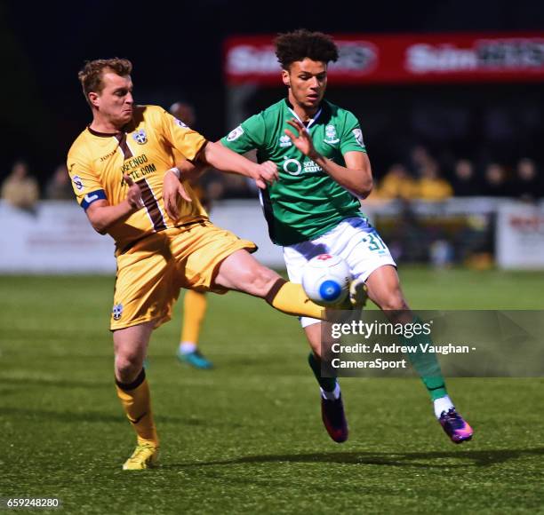 Sutton United's Jamie Collins vies for possession with Lincoln City's Lee Angol during the Vanarama National League match between Sutton United and...