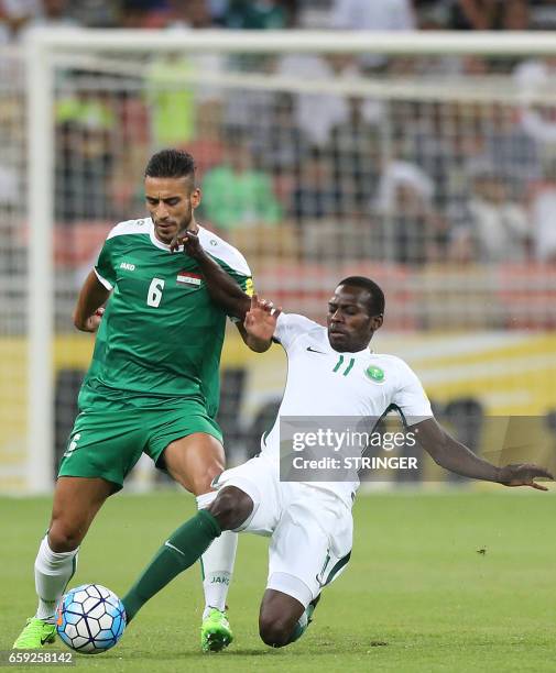 Saudi Arabia's Abdulmalek al-Khaibri tackles Iraq's Ali Adnan Kadhim during the Asian Cup qualifying football match between Saudi Arabia and Iraq at...